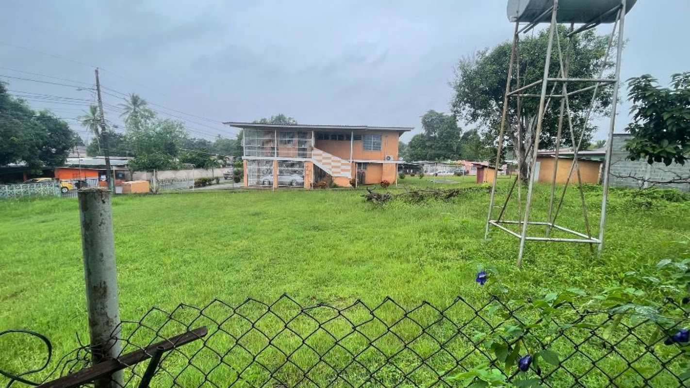 Fenced grassy lot with trees and parking at MetroPark Juan Díaz Panama City
