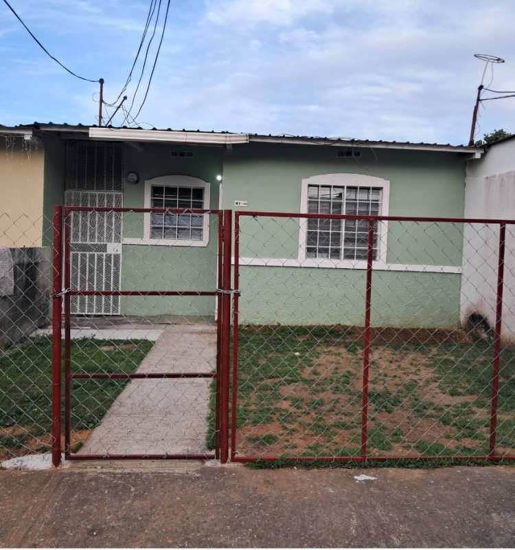 Single-story green house with red fence small yard rental Pacora Panama City