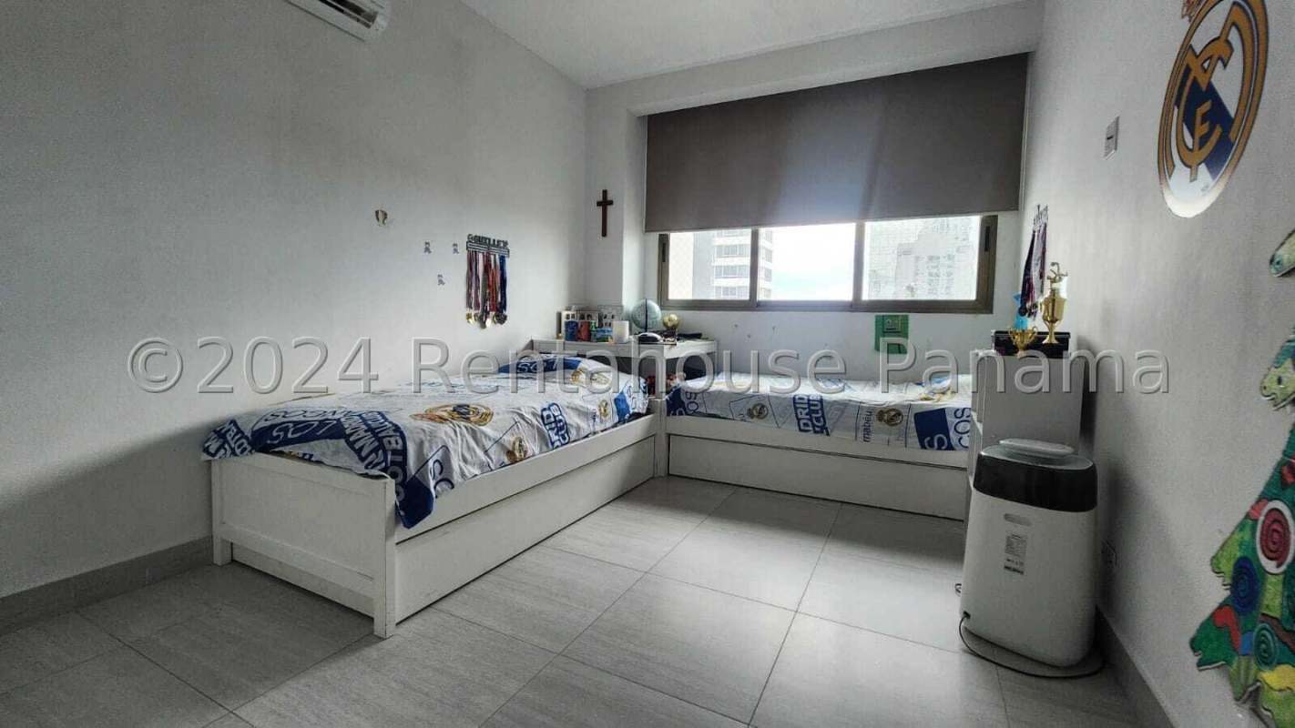 Spacious children's bedroom with two beds, large window, city views, and sports-themed decor at PH Parkview Panama