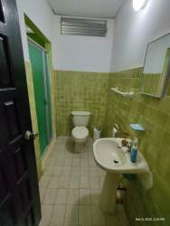 Simple bathroom with green tile, shower glass enclosure sink house rental La Pintada Coclé