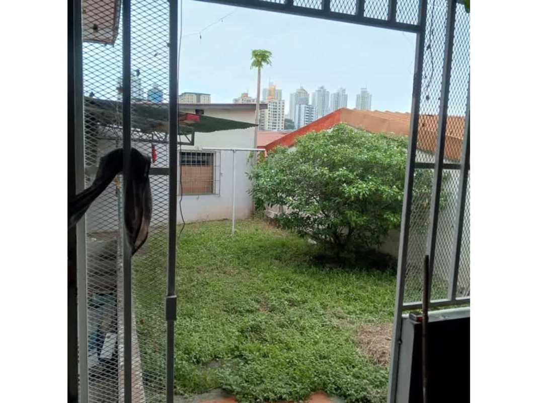 Private backyard with grass, cityscape in rental house Bethania Panama City
