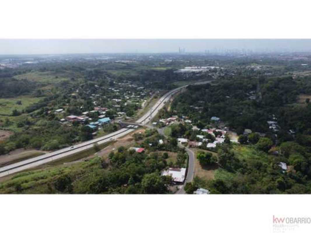 Aerial view of suburban outskirts land with major highway and city skyline distant