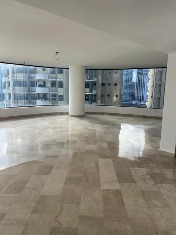 Large living room with floor-to-ceiling curved windows and marble floors, ocean view at PH The Plaza Punta Paitilla