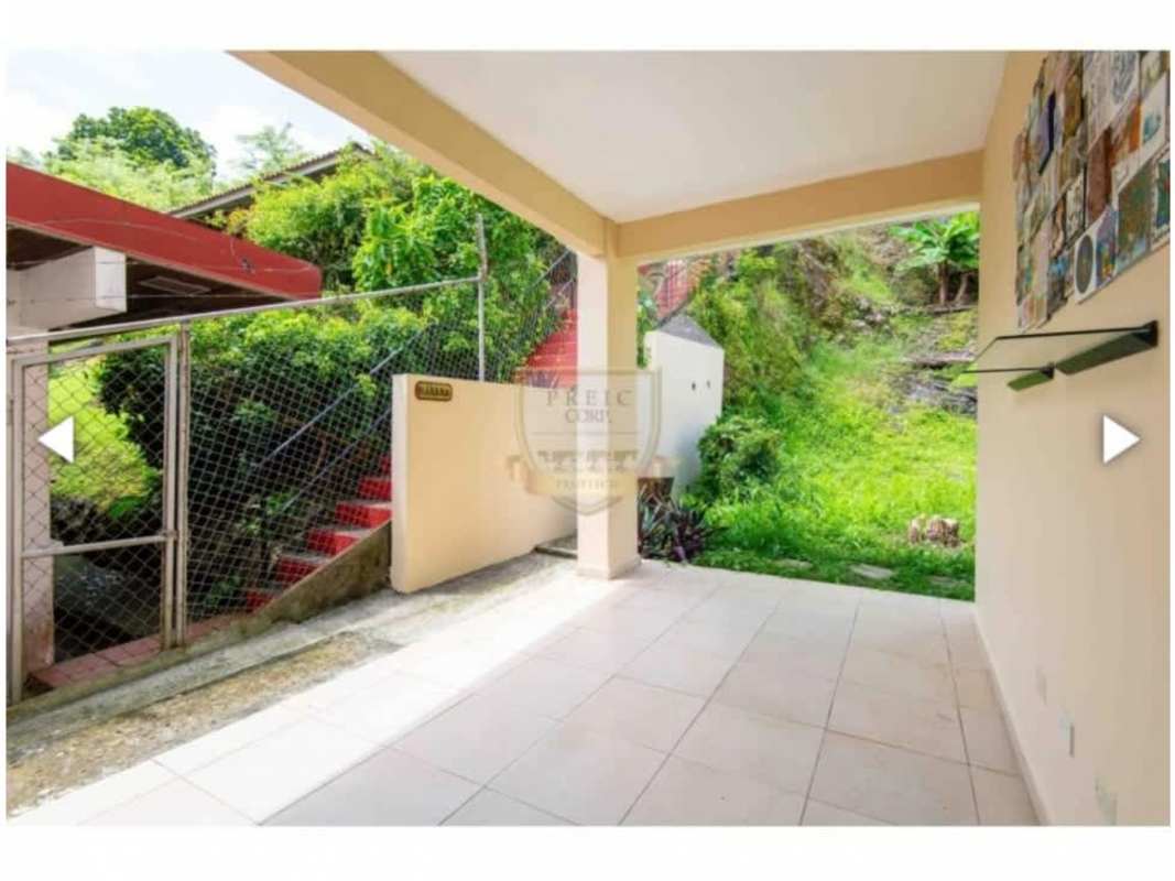 Covered tiled patio with small garden area and outdoor staircase in Bethania family house Panama