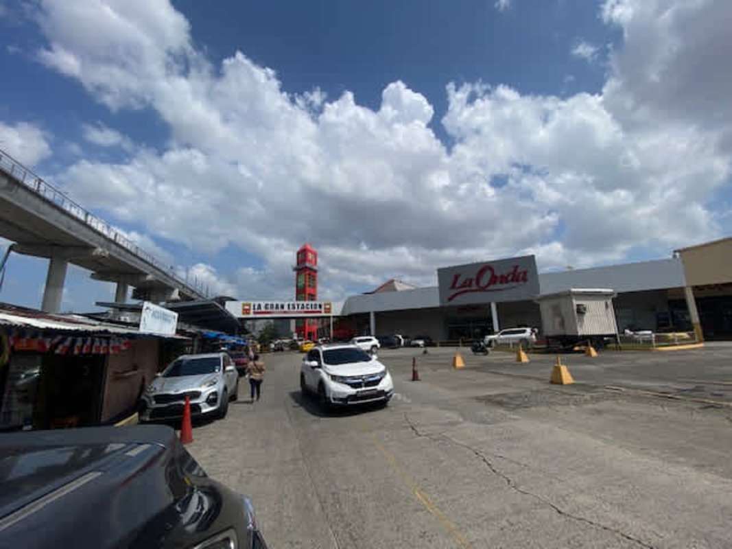 Shopping mall exterior with parking, clock tower and metro line at La Gran Estación San Miguelito Panama City