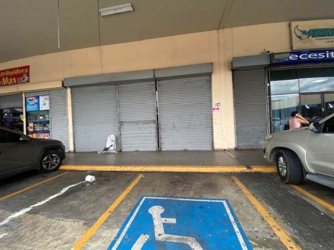 Strip mall storefronts with metal shutters and accessible parking La Gran Estación Panama City
