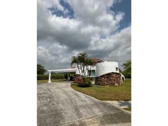 Contemporary living room with large windows garden views wicker sofas in Vistamar Beach Villa Panama