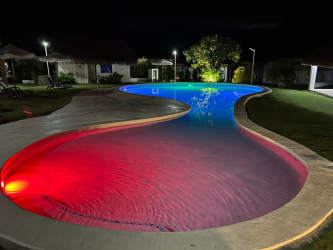Color LED lit pool and landscaped area under night sky at Ibiza Beach Residences Rio Hato Panama
