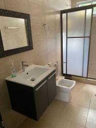 Bathroom with glass shower enclosure and modern fixtures inside 3-bedroom villa at Ibiza Beach Residences Rio Hato