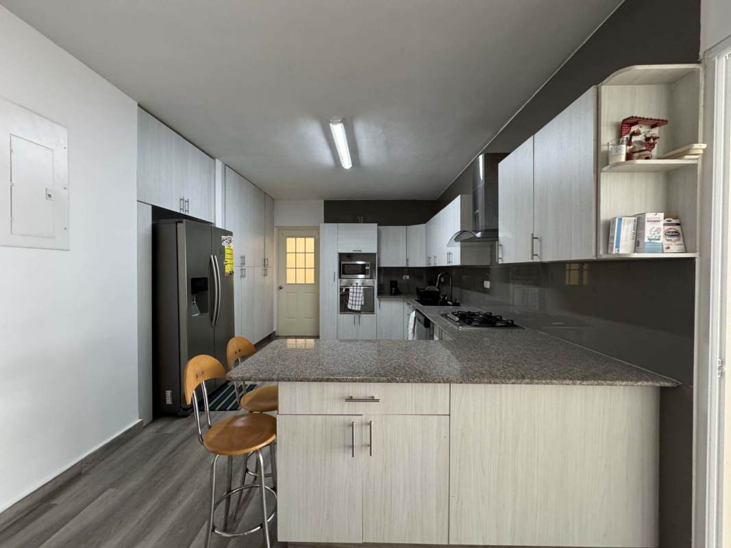 Living room with sectional sofa, neutral decor, and entertainment unit Costa del Este house