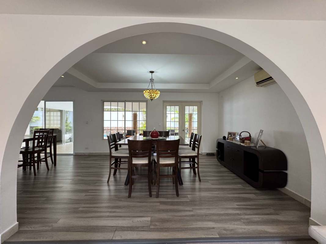 Contemporary dining with archway and wood floors in Costa del Este house