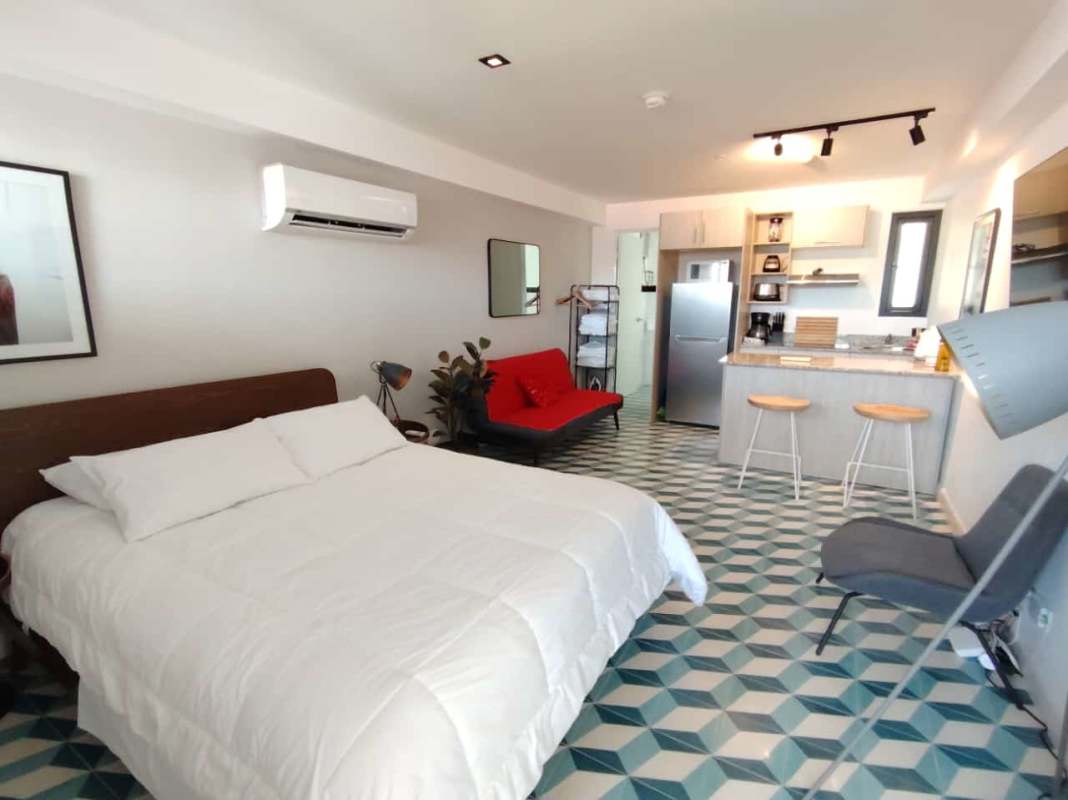Bathroom with glass shower enclosure, pedestal sink and blue geometric tiles, PH La Manzana Casco Antiguo Panama