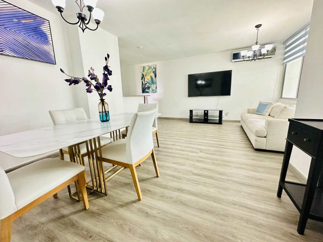 Narrow galley kitchen with granite countertops, gas stove, white cabinets, access to terrace