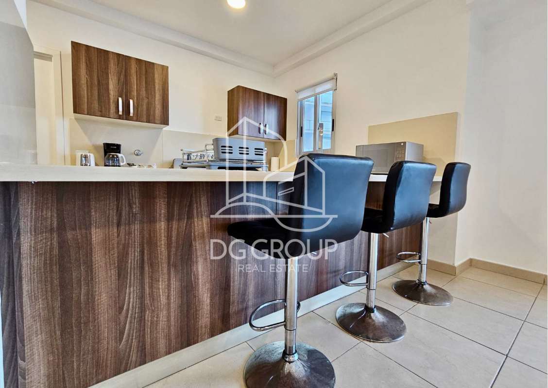 Contemporary kitchen with wood cabinetry, granite counters, gas stove in Punta Pacifica PH Oasis on the Bay apartment