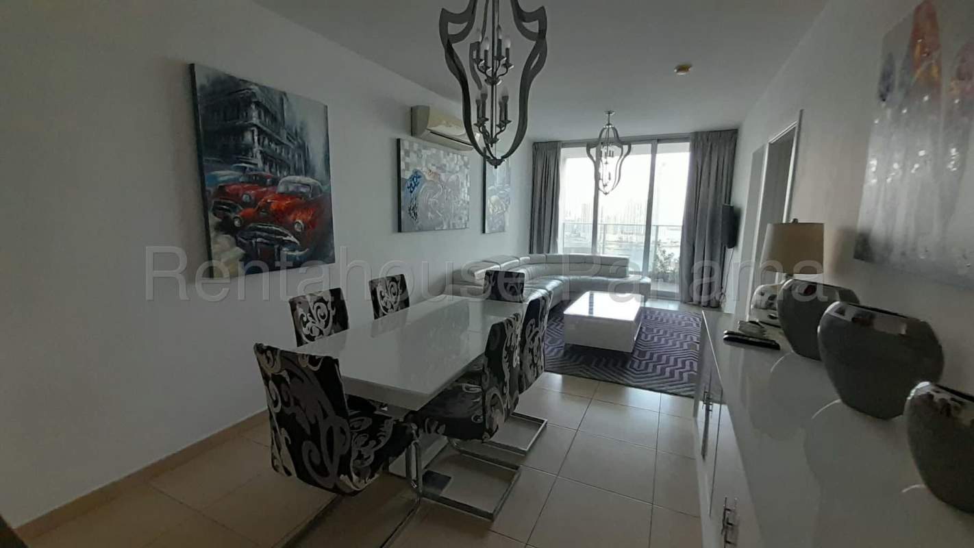 Bright living-dining space with floor-to-ceiling glass and ocean city view in PH Miramar Panama