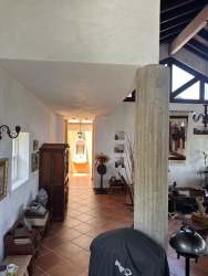 Estate entrance with paved driveway and lush greenery at Finca Naso Chame Panama