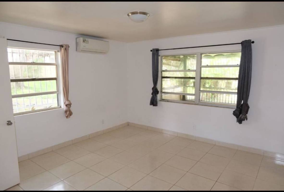 Bedroom with tiled floor and windows overlooking gardens in Clayton Panama apartment rental