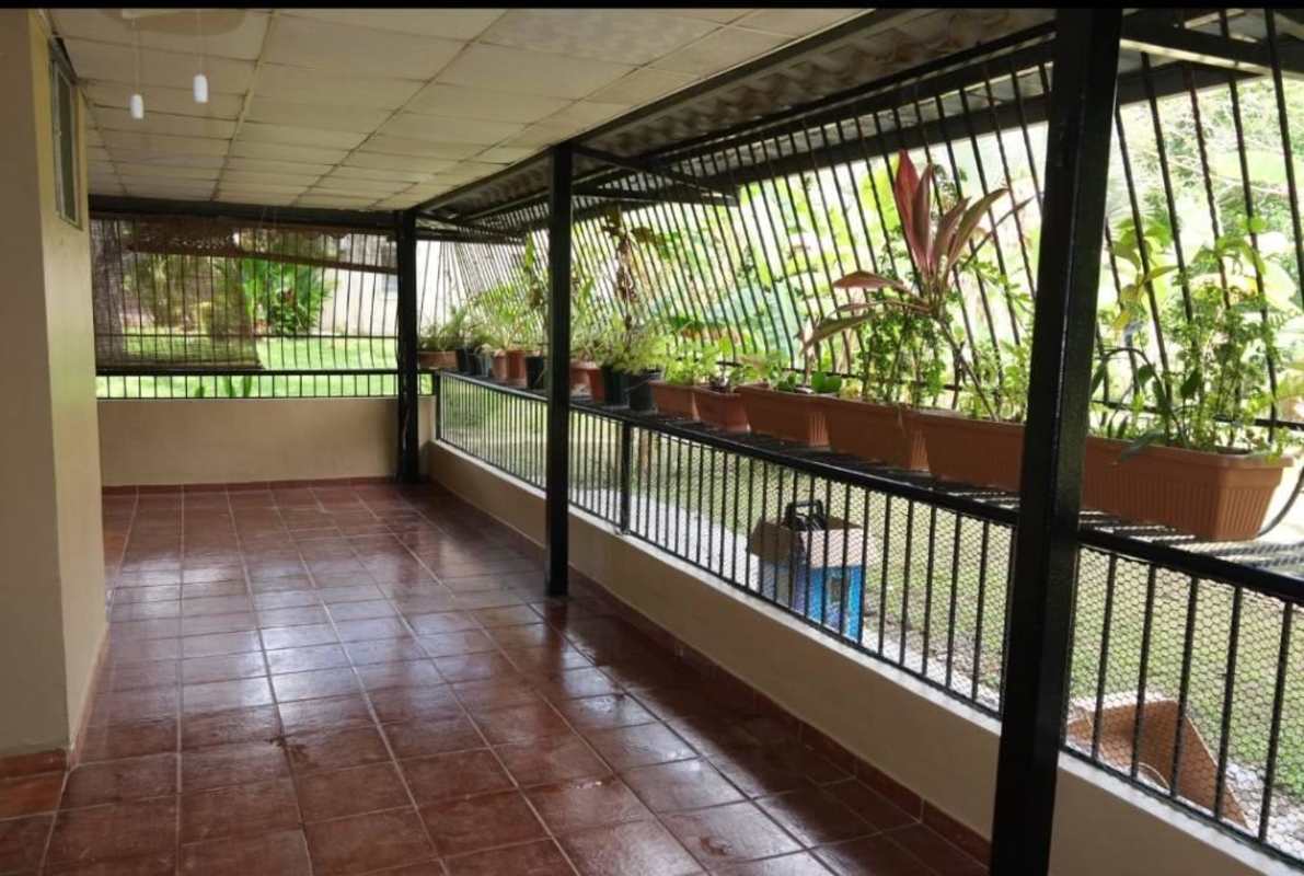 Glass enclosed veranda with tiled floor overlooking tropical gardens in Clayton Panama rental