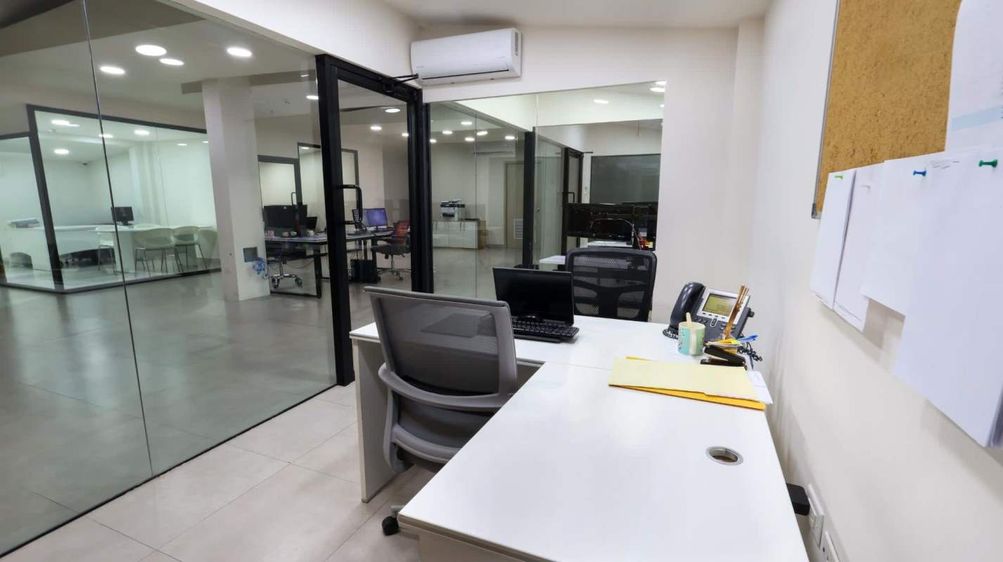 Modern office room with glass partitions white desks and office chairs Panama commercial