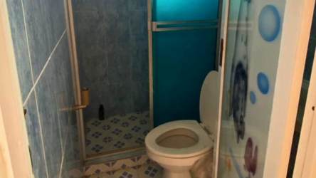 Small bathroom with toilet and glass-enclosed shower in house Ciudad del Futuro Panama Oeste