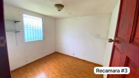 Bedroom with wood-patterned flooring and white walls in Panama Oeste affordable home