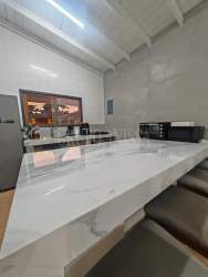Bright kitchen with marble counters, breakfast bar, window with garden views in Coronado Panama