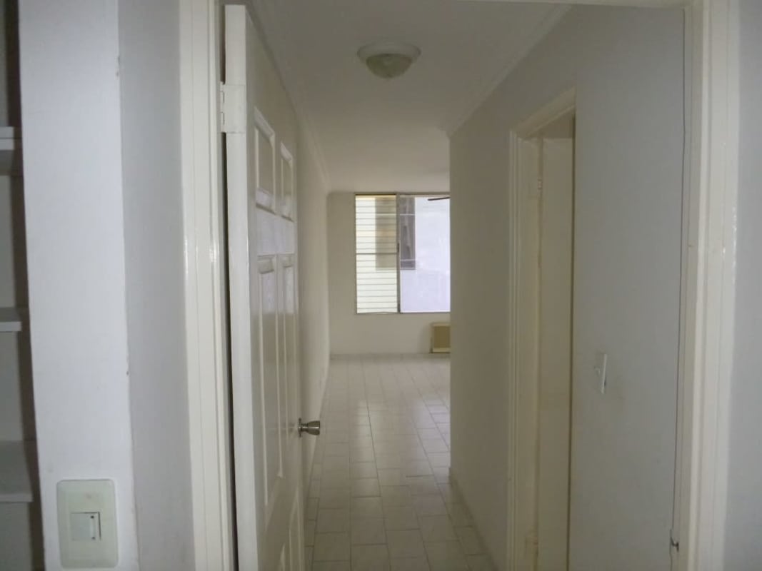 Bright hallway inside apartment with white tile flooring and neutral walls PH Ocean View Panama