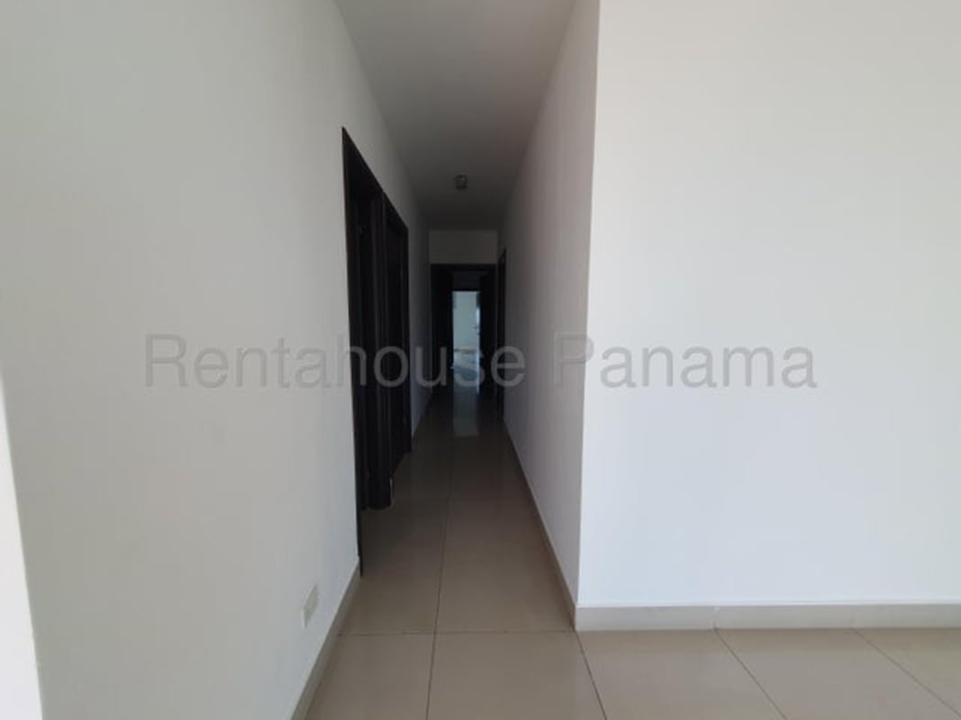 Minimalist corridor with beige floor tiles and dark wood closets in PH LaCosta Costa del Este Panama City apartment