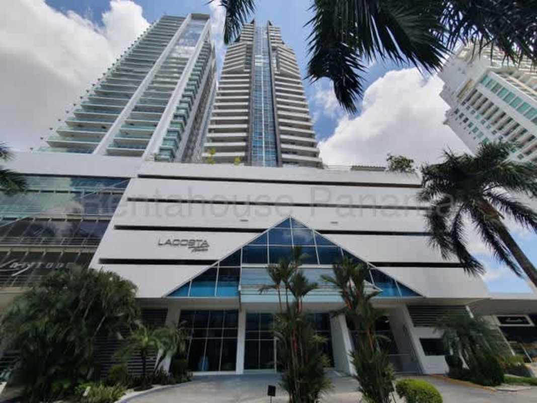 Modern high-rise tower facade with glass balconies lush landscaping PH LaCosta Costa del Este Panama City