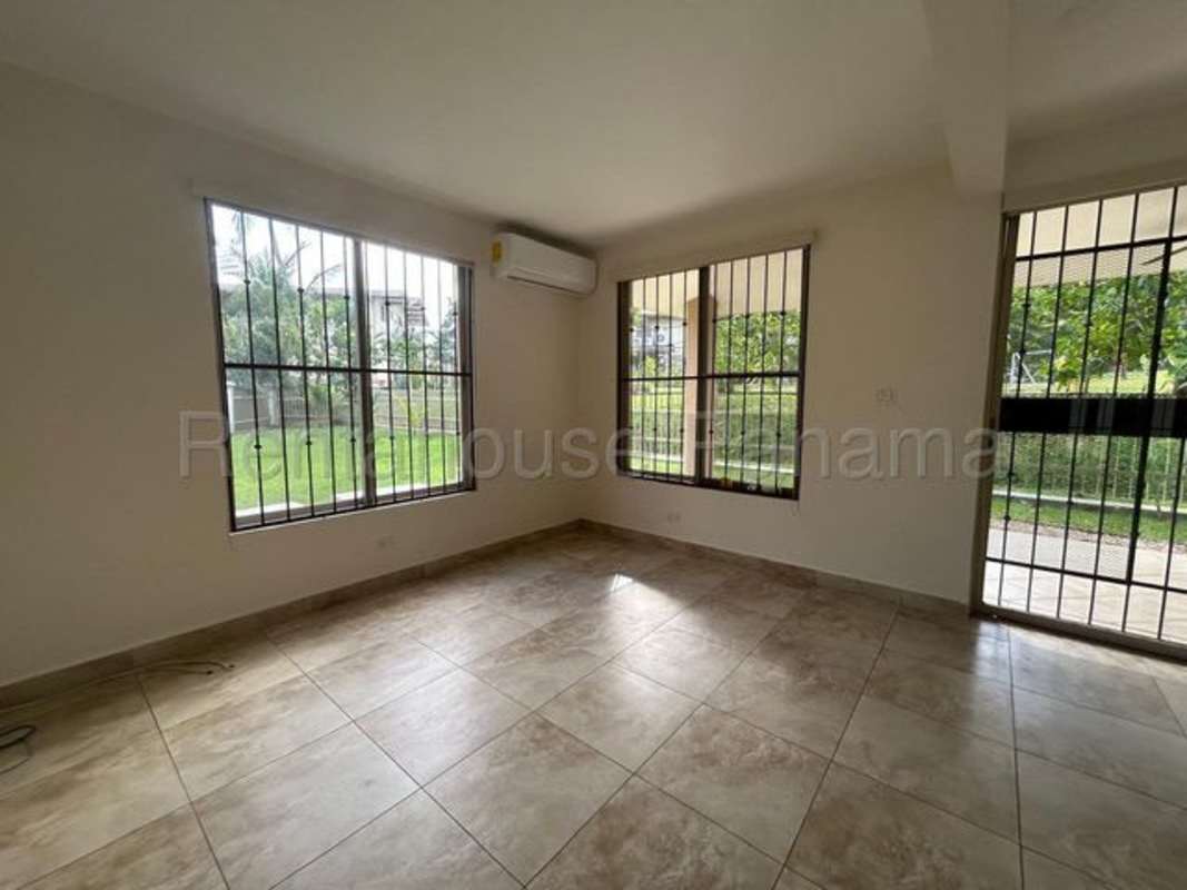 Kitchen with granite countertops, wooden cabinets, gas stove Embassy Gardens house Panama City