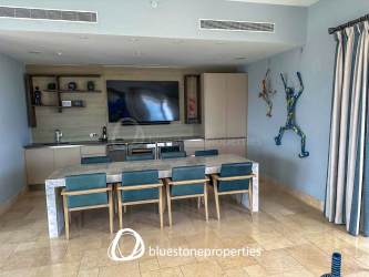 Elegant dining area with glass table leading to terrace and ocean view in Buenaventura Panama Penthouse