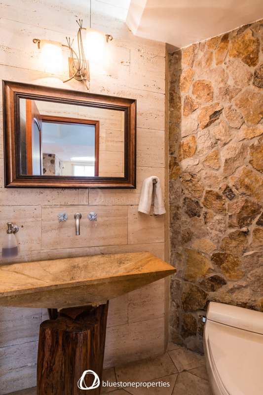 Luxury bathroom with stone accent wall and custom sink in Altos del Golf Panama