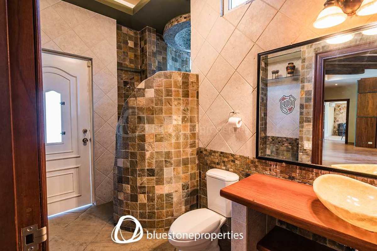 Rustic outdoor kitchen with BBQ grill and stone counter in luxury home Altos del Golf