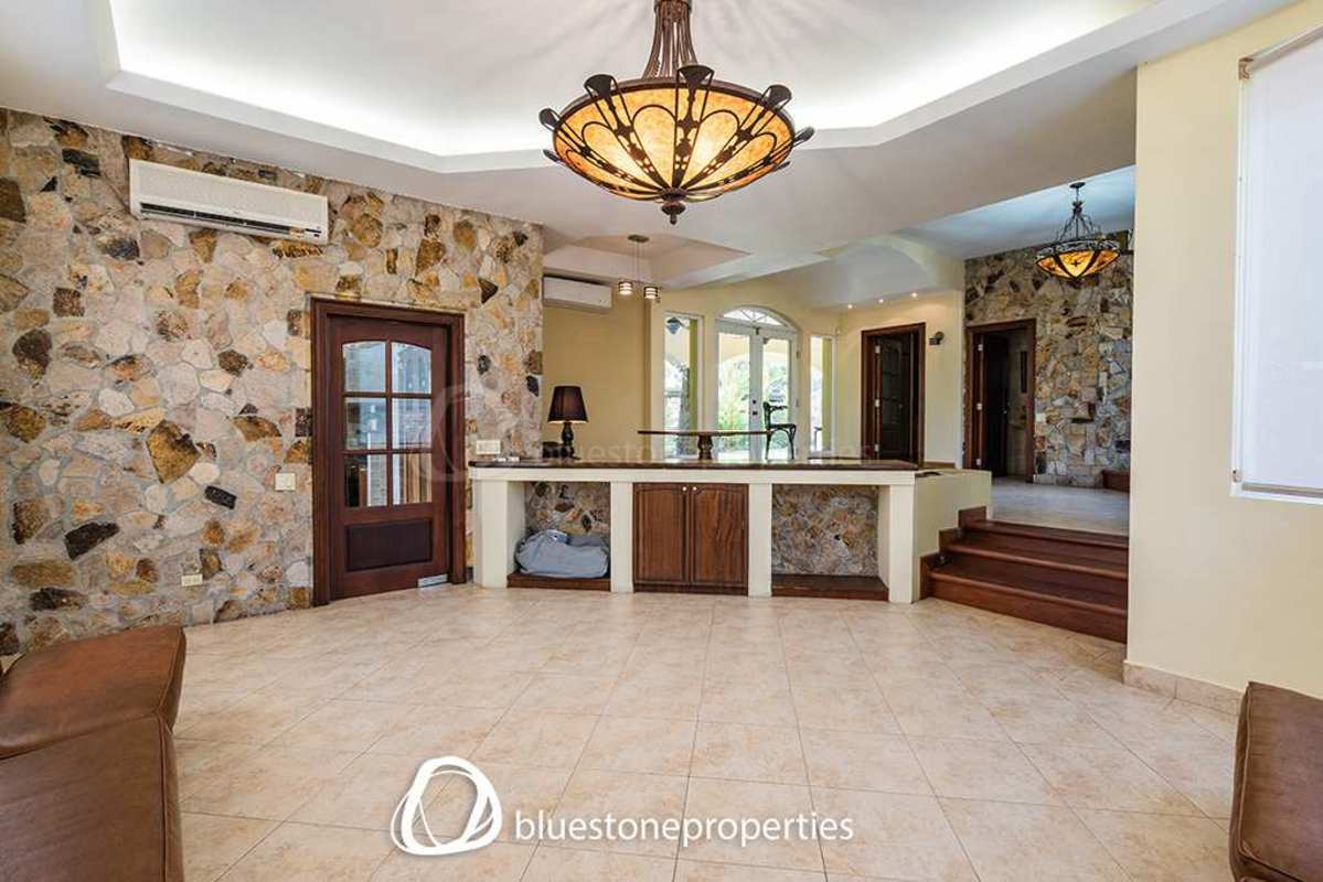 Entry area with stone accents, chandeliers, split lighting in Panama luxury residence