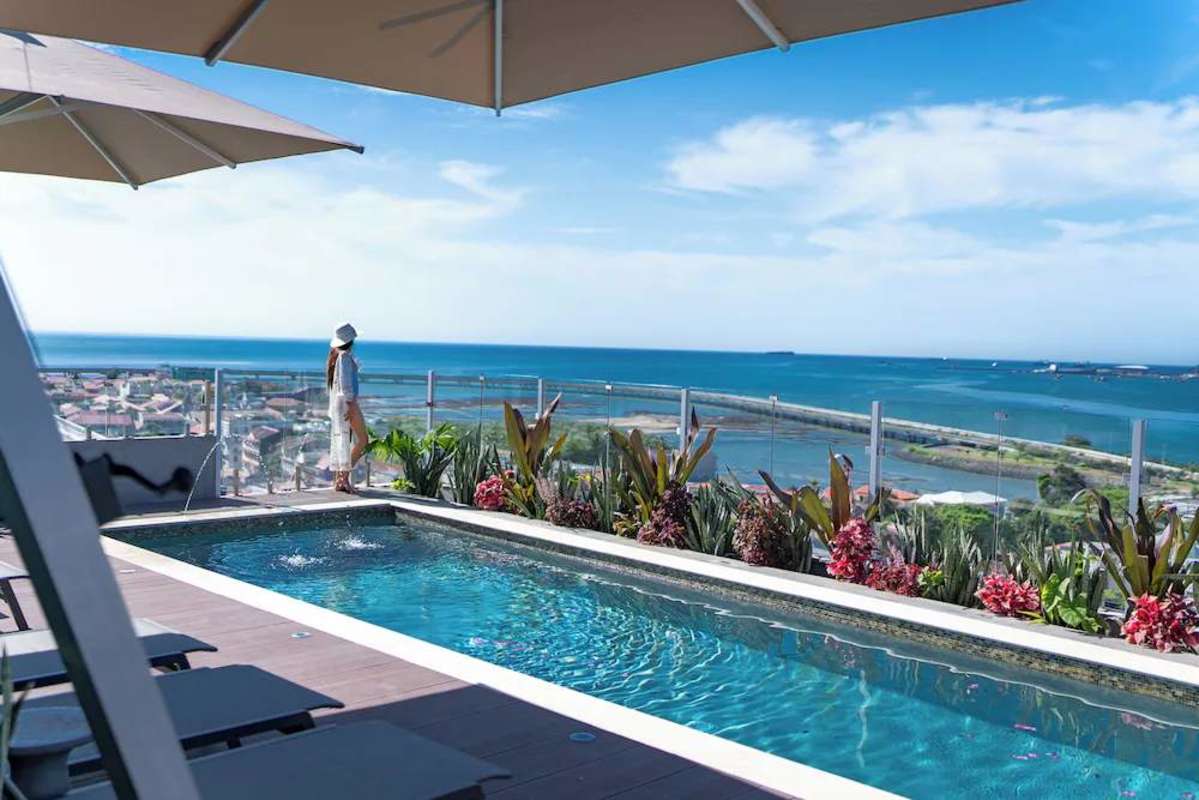Modern minimalist bedroom with accent wood wall, AC, contemporary bedding at PH Casco View Casco Viejo Panama