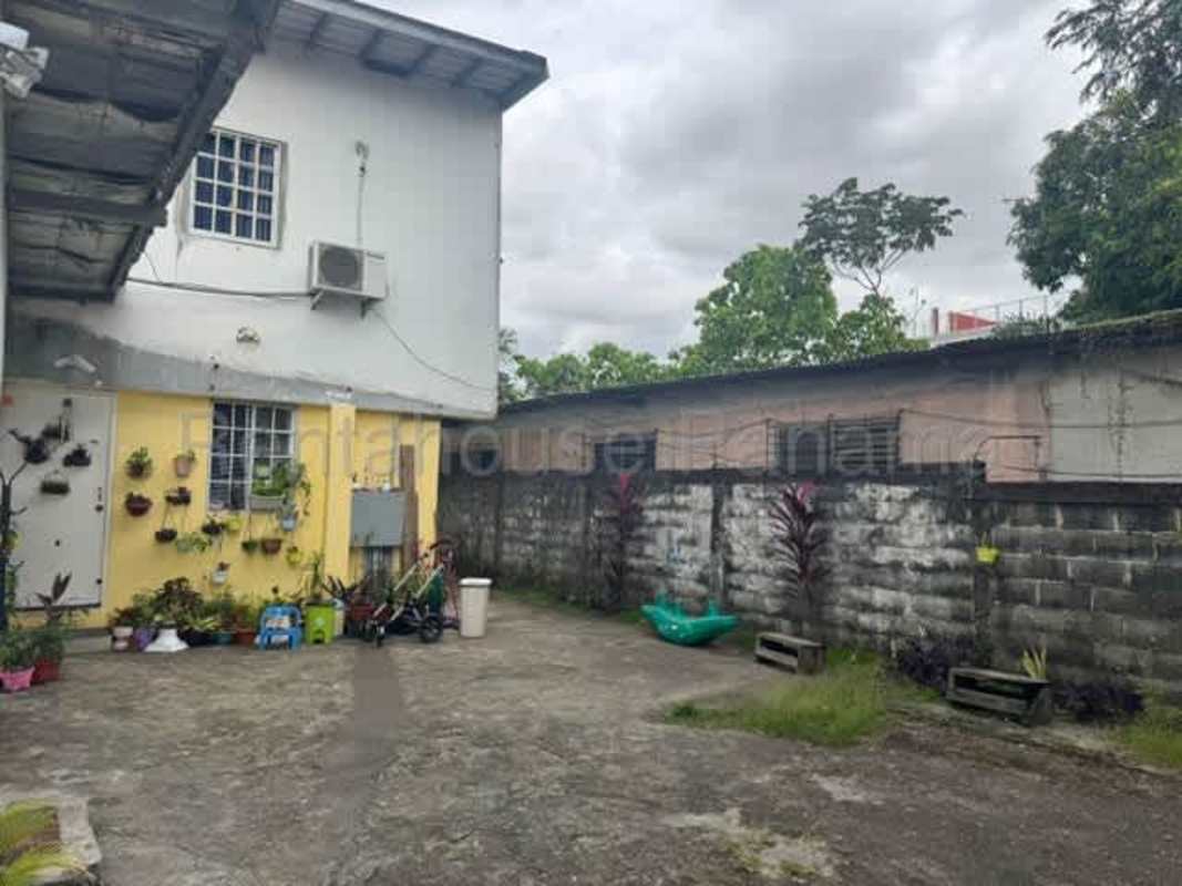 Concrete patio courtyard with two-story home facade Rio Abajo income-producing house Panama