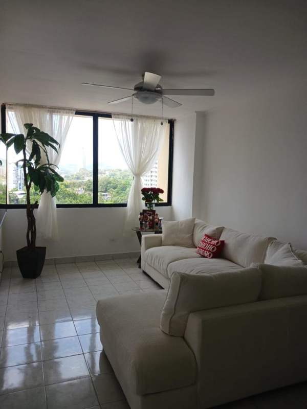 Bright living room with white sectional, large windows and tiled floors PH Mirador del Edén Panama