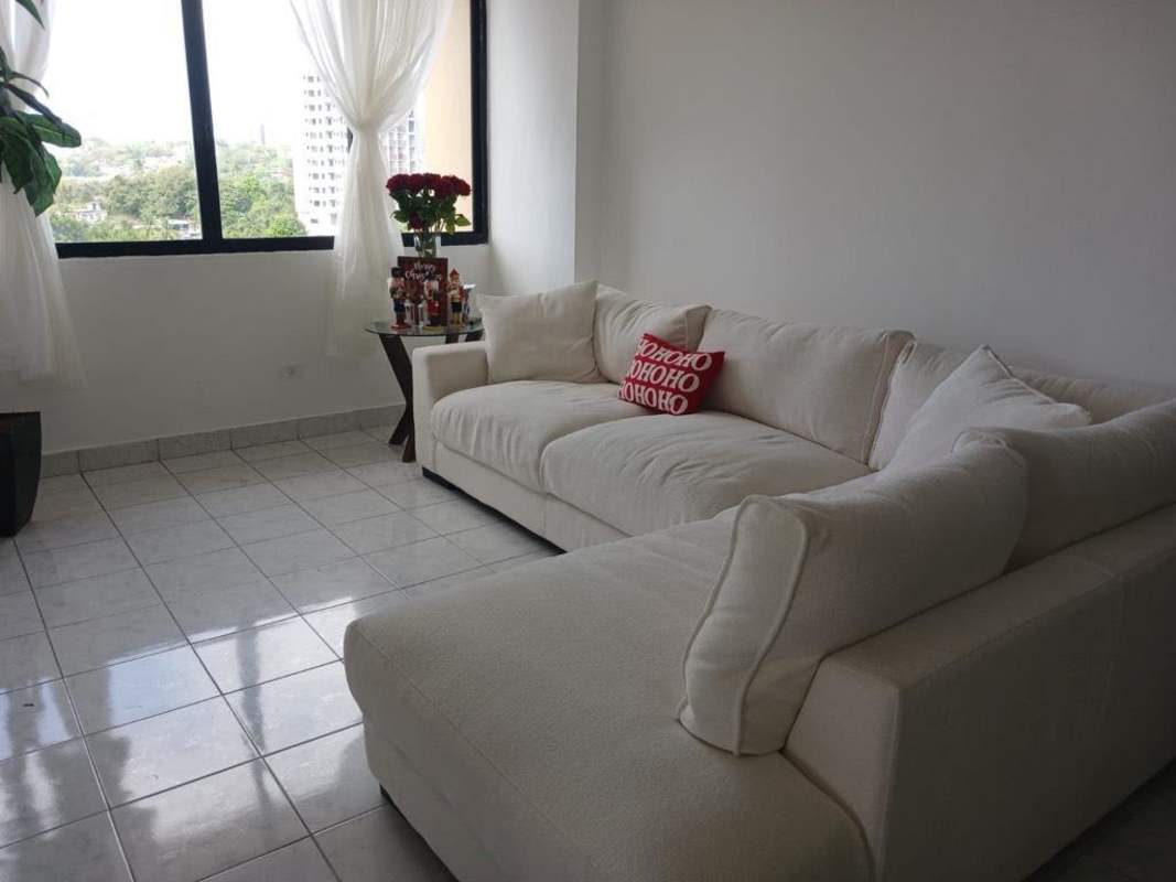 Living room with sectional sofa, large window, holiday decorations PH Mirador del Edén Panama