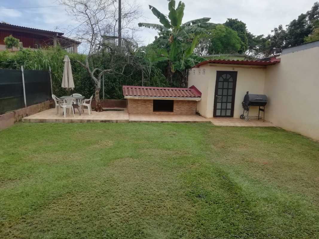 Garden view with brick dog house, tiled patio, and lawn in San Antonio Panama rental house