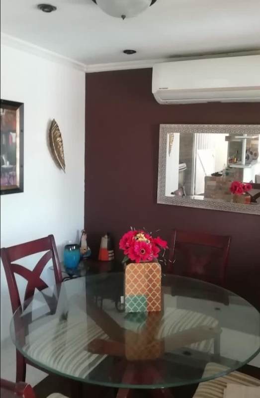Dining room with glass dining set, air conditioning, and wall art in Praderas de San Antonio Panama