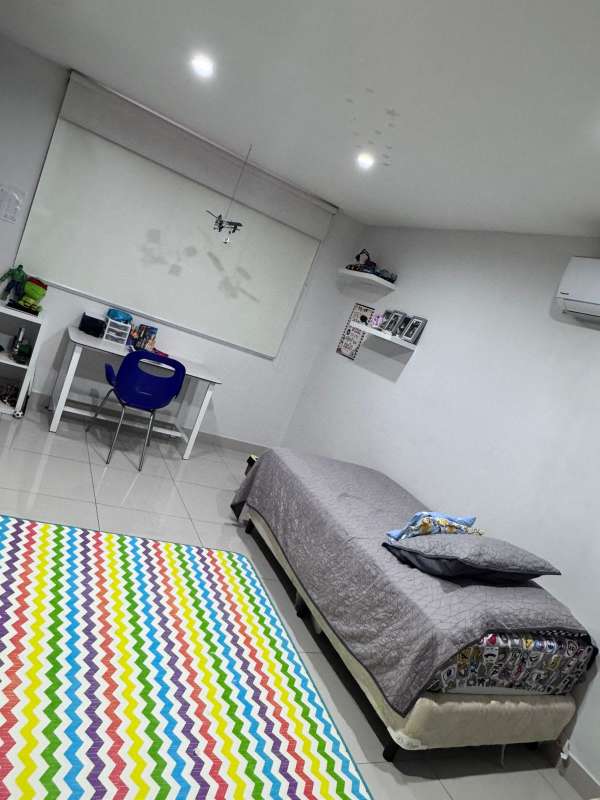 Minimalist bedroom with study desk, shelves, AC and colorful rug in Panama family home