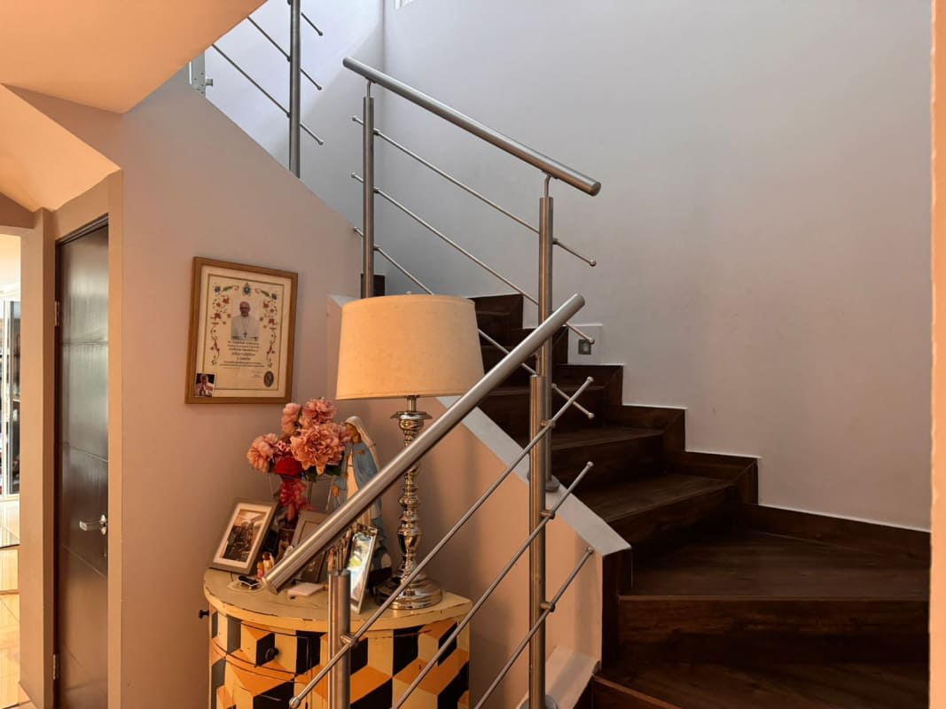 Hallway feature decorative table, flowers and modern stairs in Panama City home Los Guayacanes