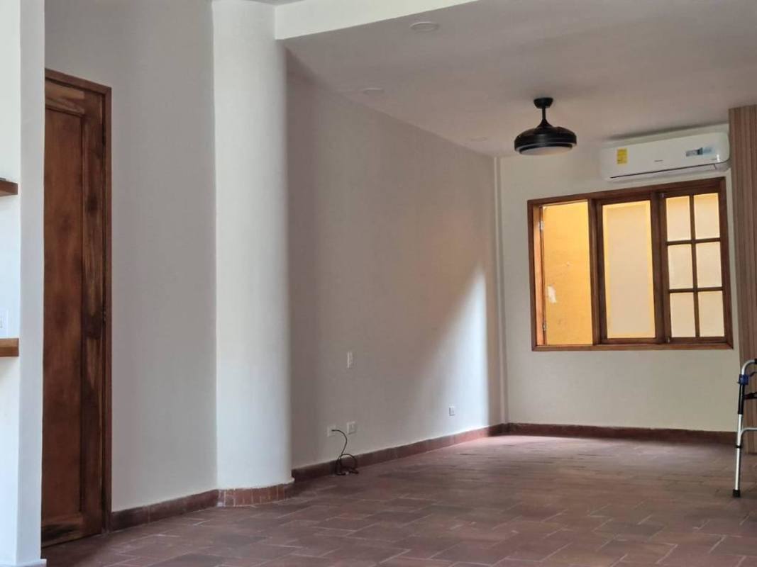 Studio living area with colonial window frames, AC and neutral tile floors Panama Casco Viejo