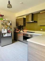 Kitchen with light wood cabinetry, built-in oven, refrigerator Howard Capira Panama