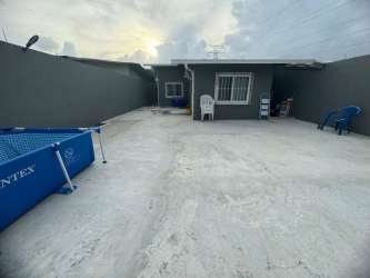Private backyard patio with gray walls, portable blue pool, outdoor seating in Las Villas de Arraiján Panama