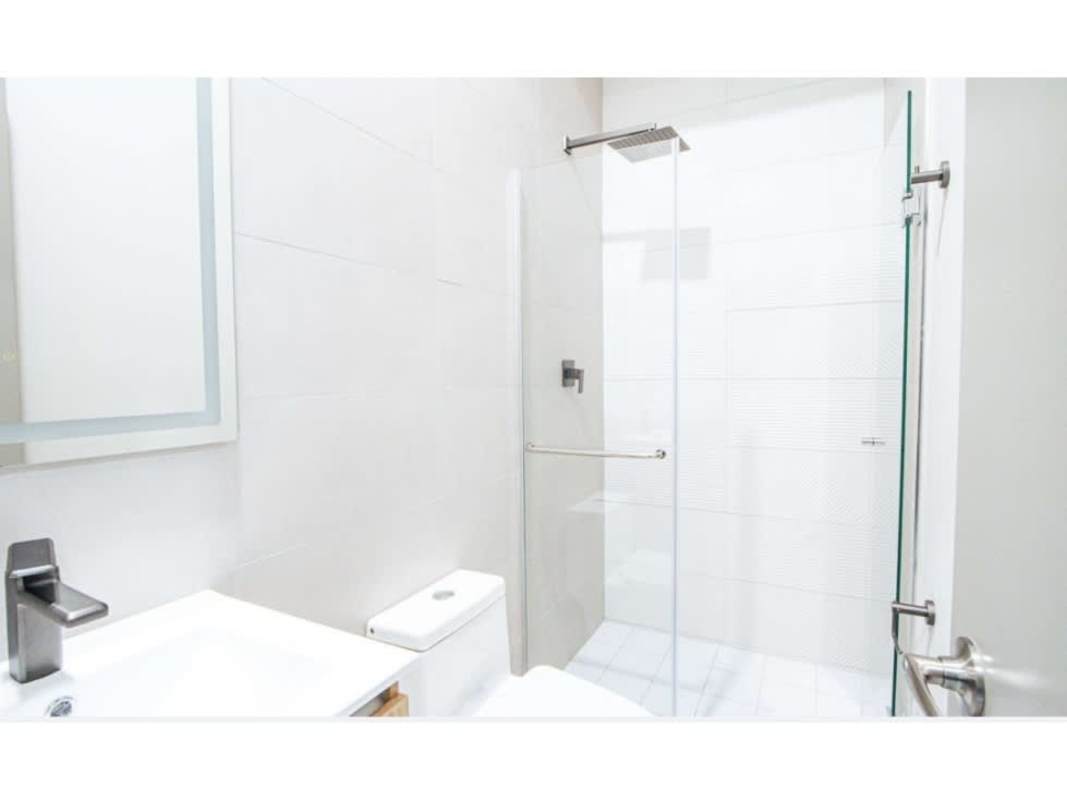 Contemporary bathroom with glass shower enclosure and modern fixtures at PH Seaside House
