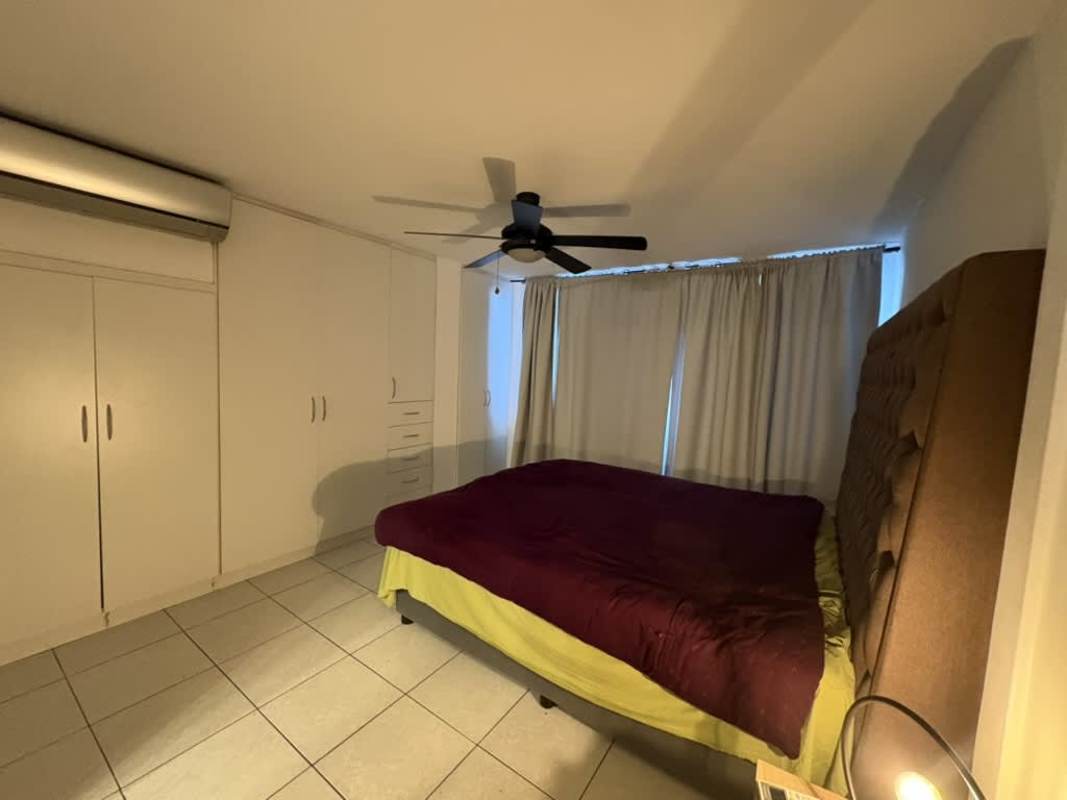 Modern bedroom with built-in closet, ceiling fan, air conditioner and window PH San Francisco Panama