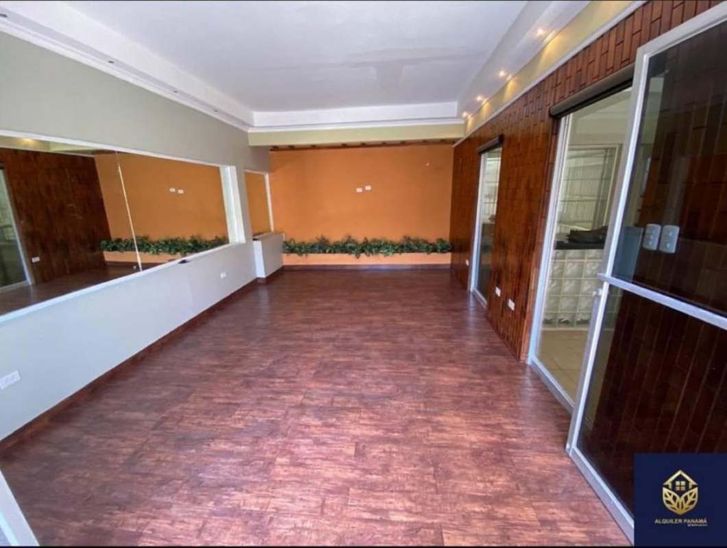 Spacious contemporary living space with accent wall, sliding doors, garden plants in El Dorado house Panama