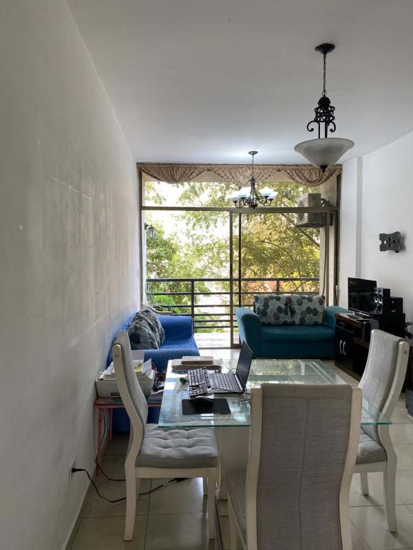 Living room with blue sofas, glass dining table, balcony view at PH Miraflores Betania Panama City