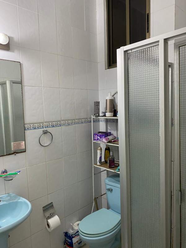Small bathroom light blue fixtures glass-enclosed shower PH Miraflores Betania Panama